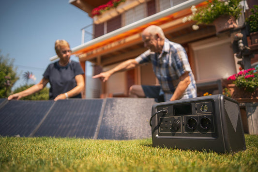 A couple prepares to install their solar panels in front of a black solar battery