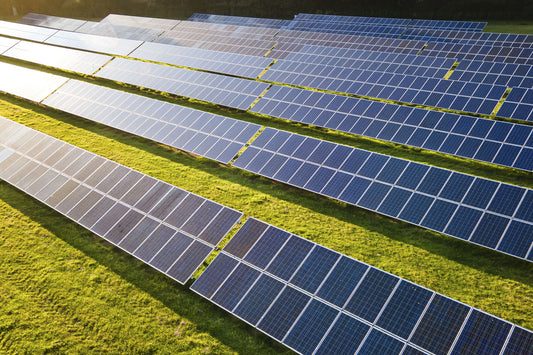 A view of a renewable energy farm with rows of solar panels