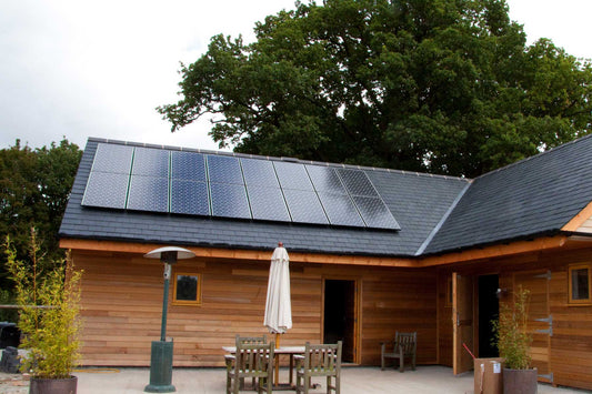 A wooden lodge with optimally angled solar panels on its roof